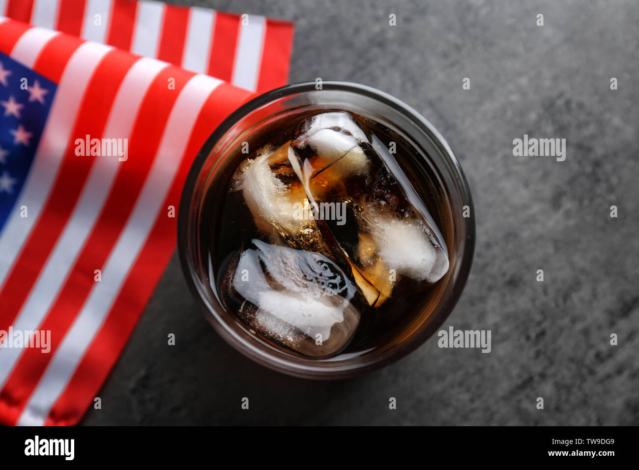 Glass of cold cola with flag of the USA on grey background Stock Photo