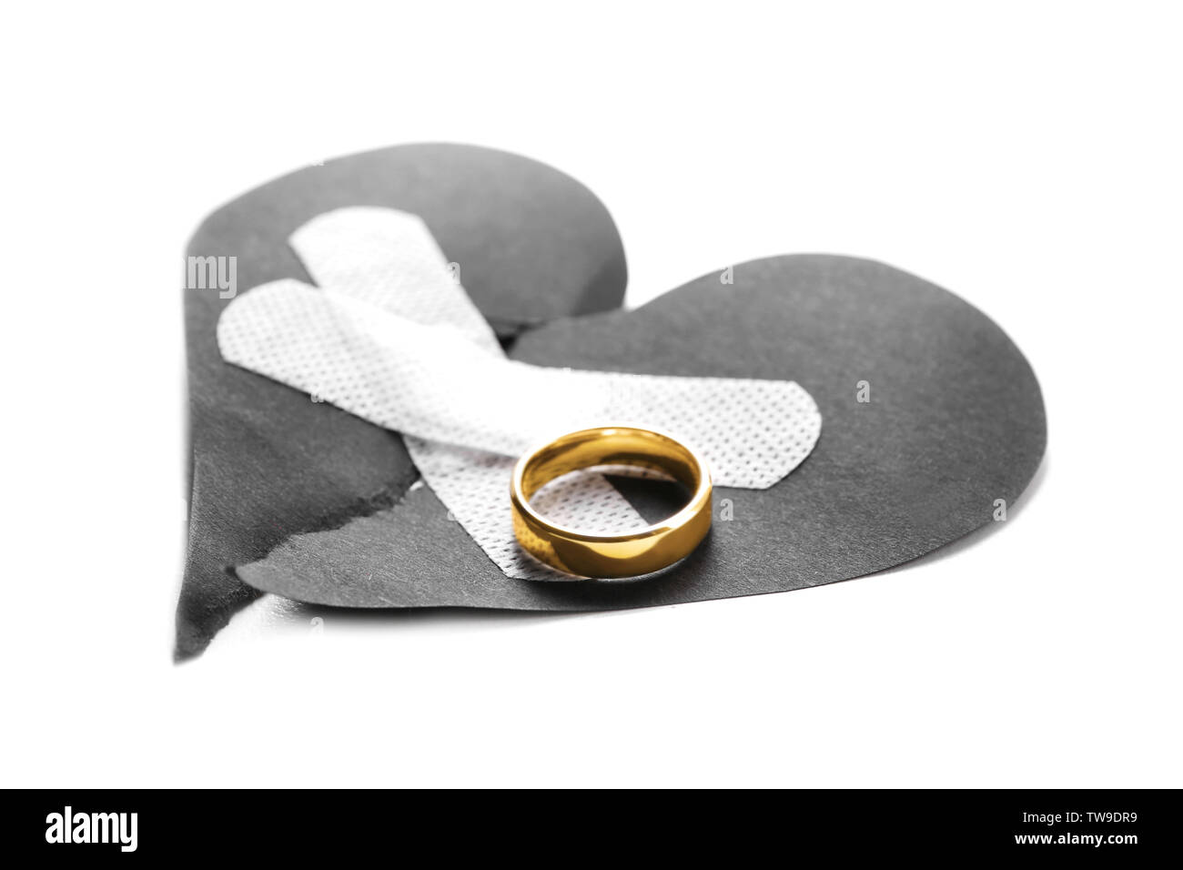 Torn paper heart with medical patches and wedding ring on white background. Relationship problems Stock Photo