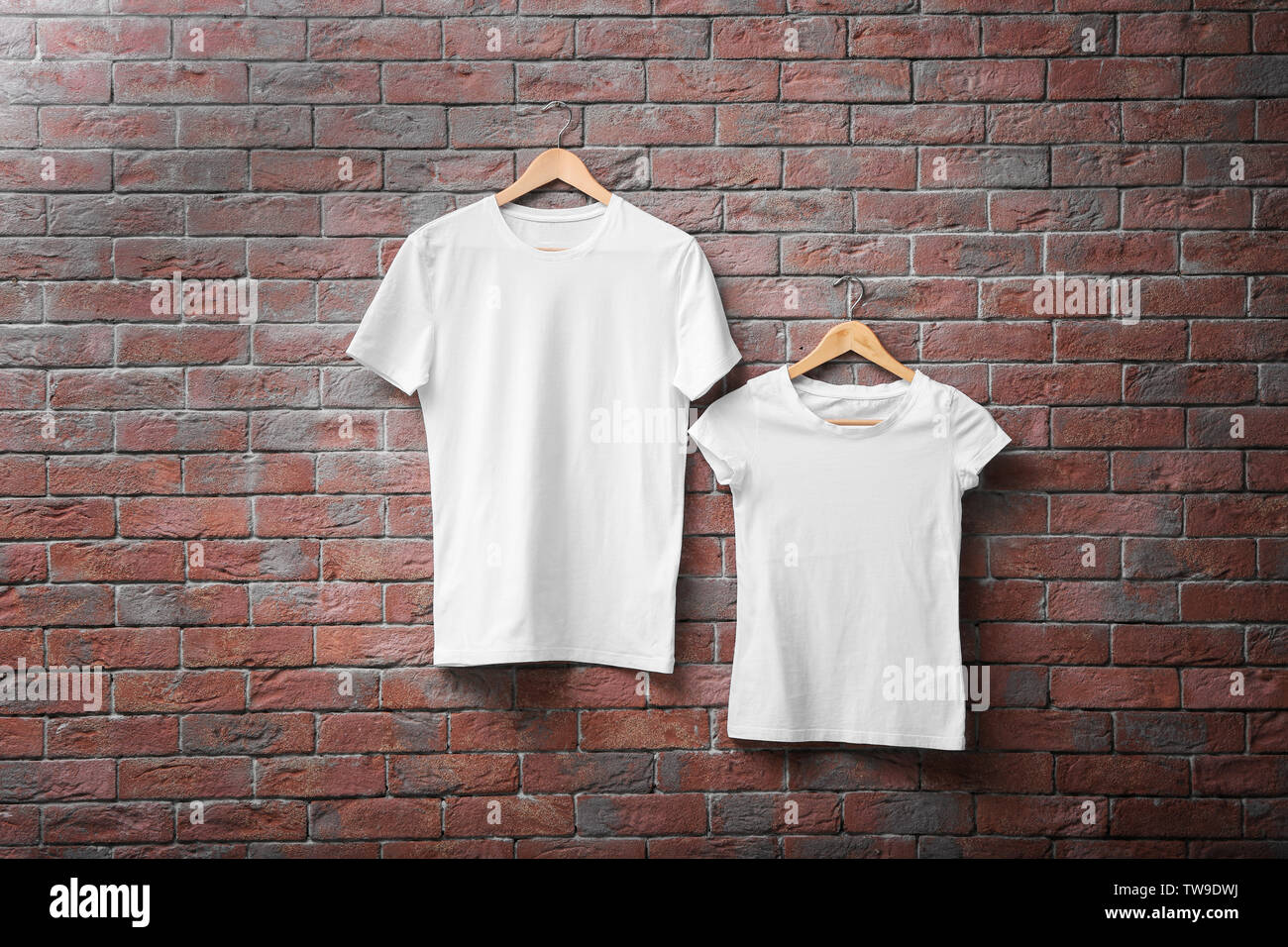 White t-shirts on brick wall background. Mock up for design Stock Photo