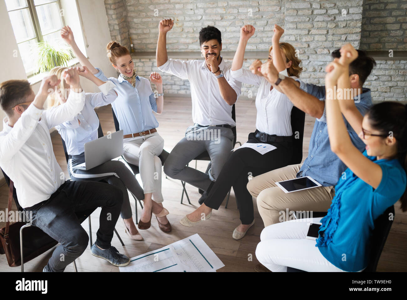 Happy success business team celebrating victory in office Stock Photo ...