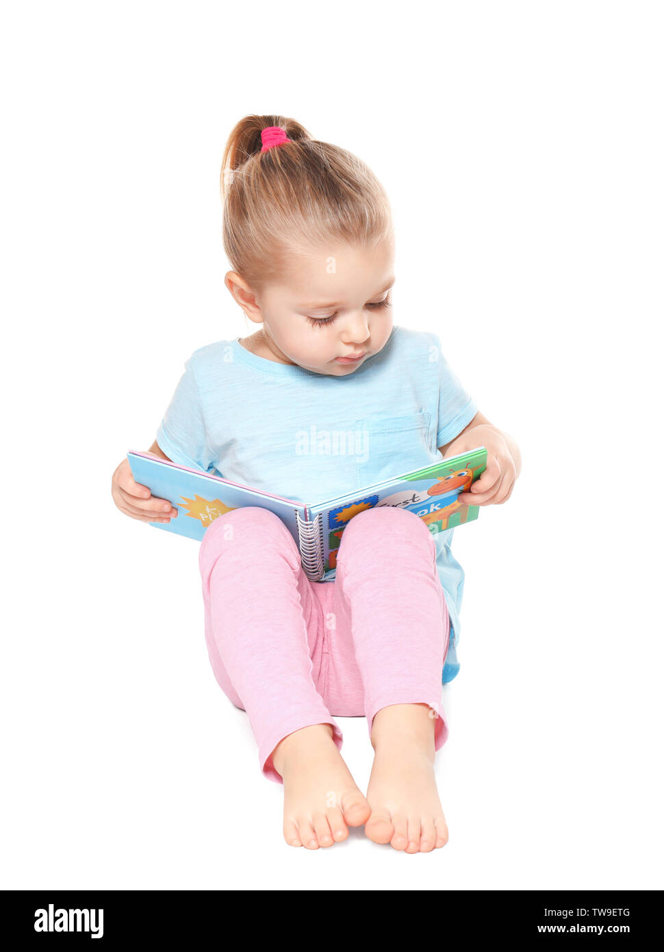 Cute little girl reading book on white background Stock Photo - Alamy
