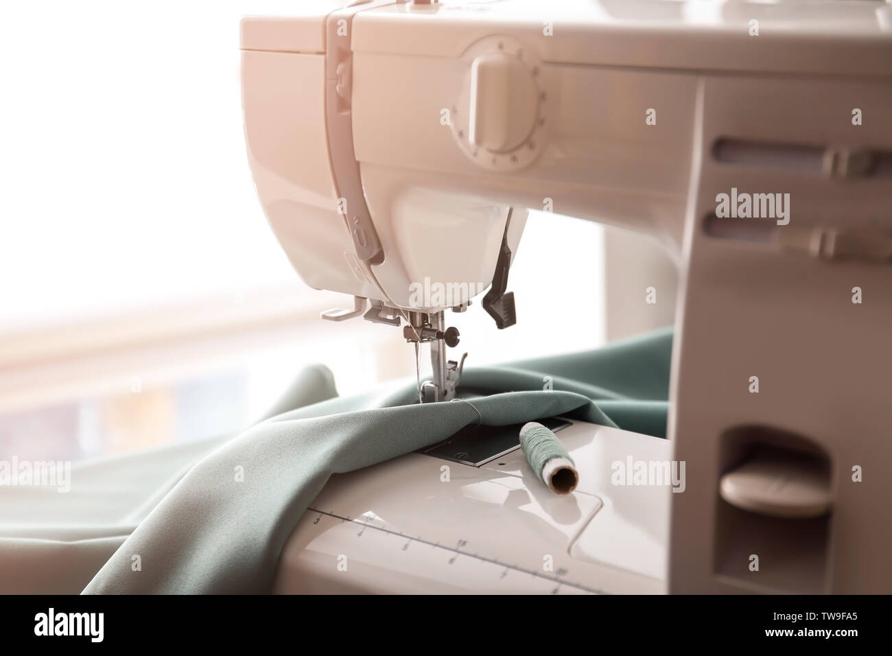 Modern sewing machine with fabric and thread, closeup Stock Photo Alamy