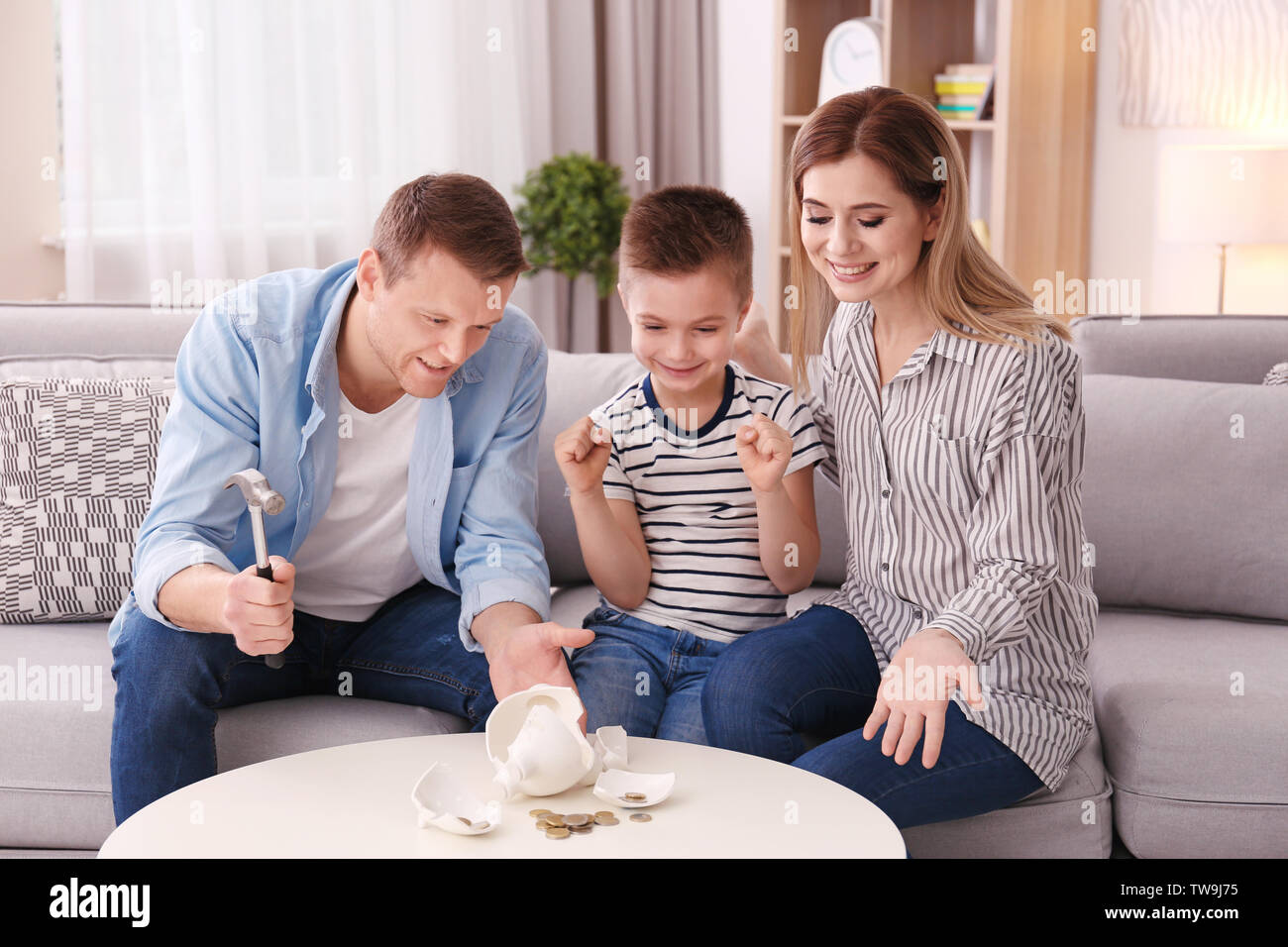 Happy family breaking piggy bank with hammer at home Stock Photo - Alamy