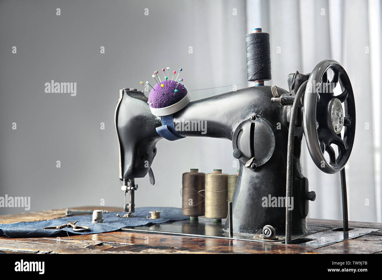 Vintage sewing machine with fabric and threads indoors Stock Photo Alamy