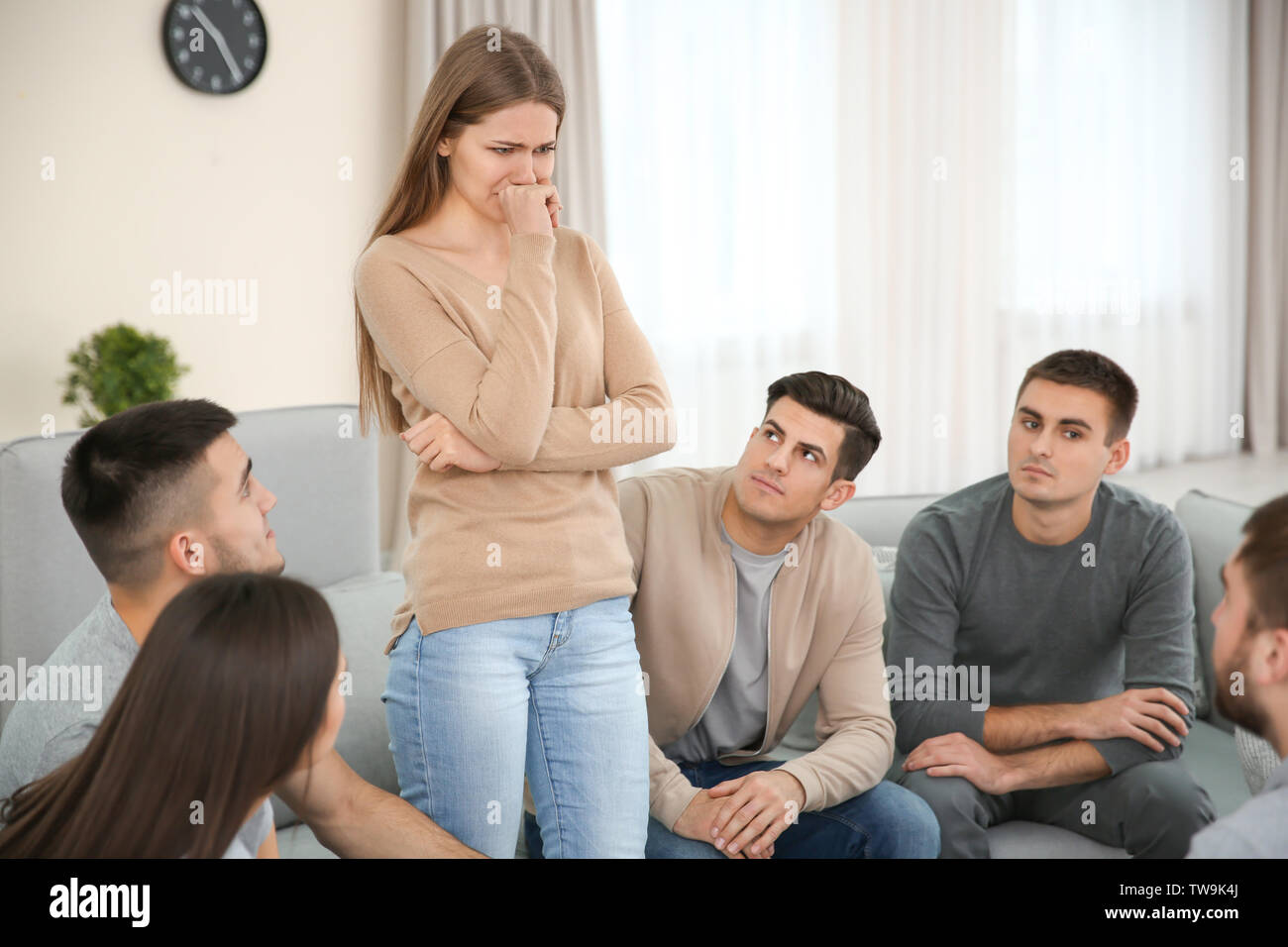 Young woman talking about her problems during group therapy Stock Photo