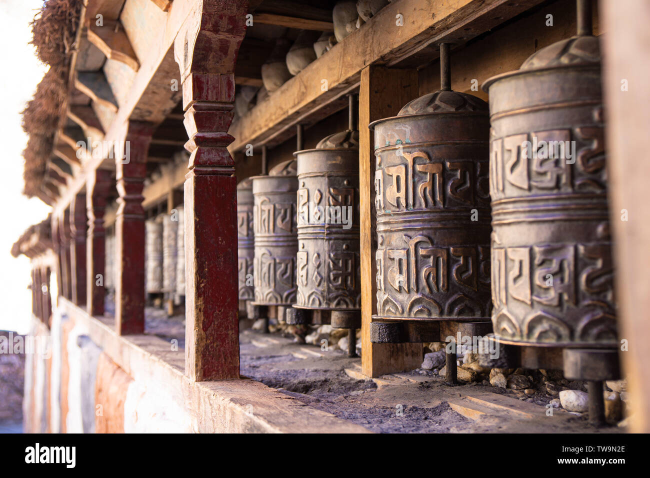 Turning prayer wheels at a Buddhist Temple in Kagbeni village, Nepal Stock Photo