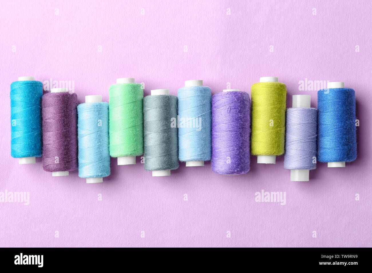 Set of sewing threads on color background Stock Photo - Alamy