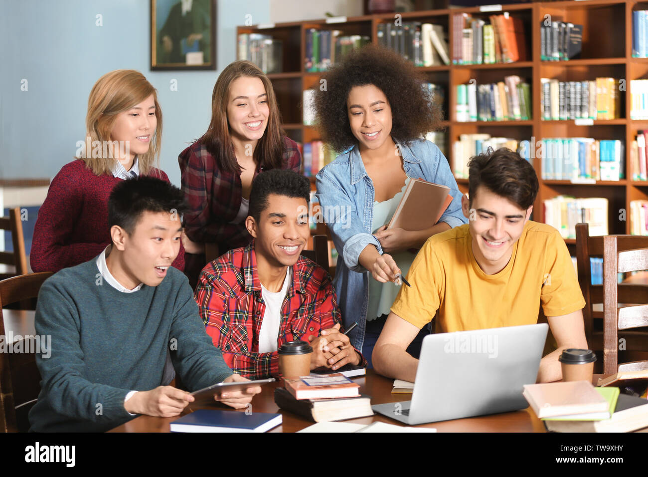 Group of students studying at table in library Stock Photo - Alamy