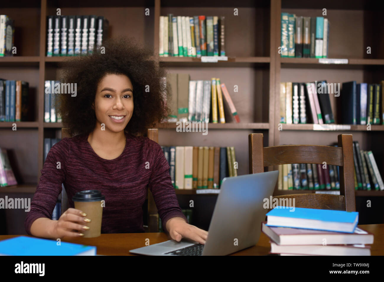 African American student with laptop studying in library Stock Photo ...