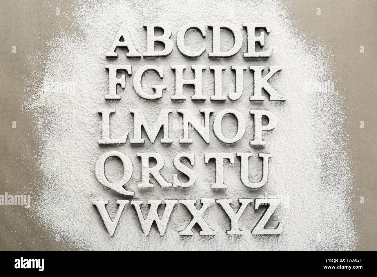 Alphabet letters on scattered flour Stock Photo