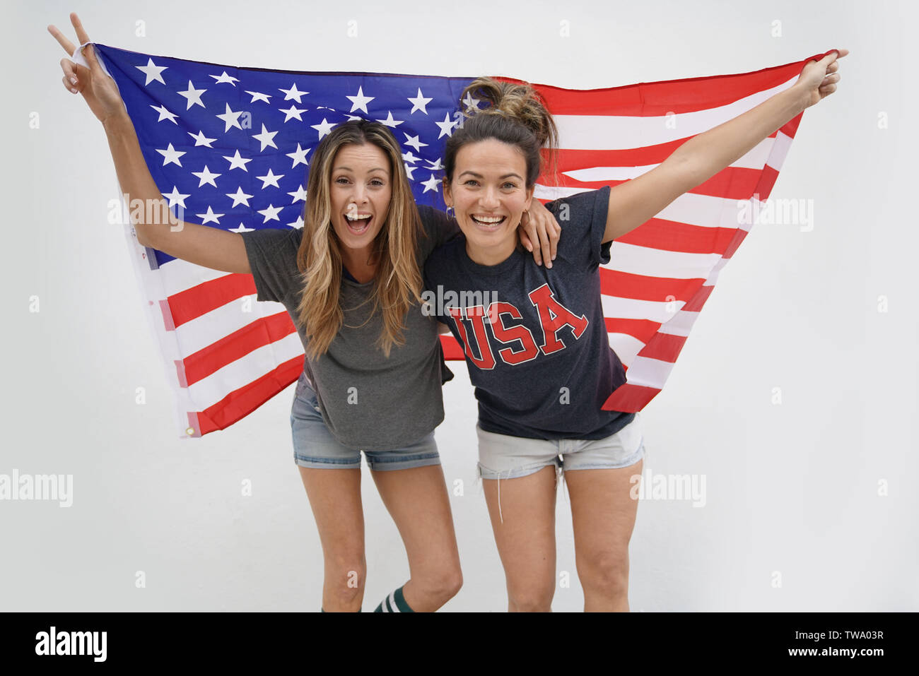 Happy energetic girls with big American flag on white background Stock ...
