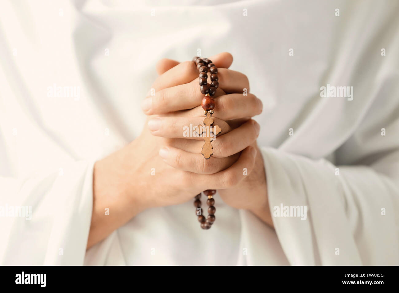 Praying monk with rosary beads, closeup Stock Photo
