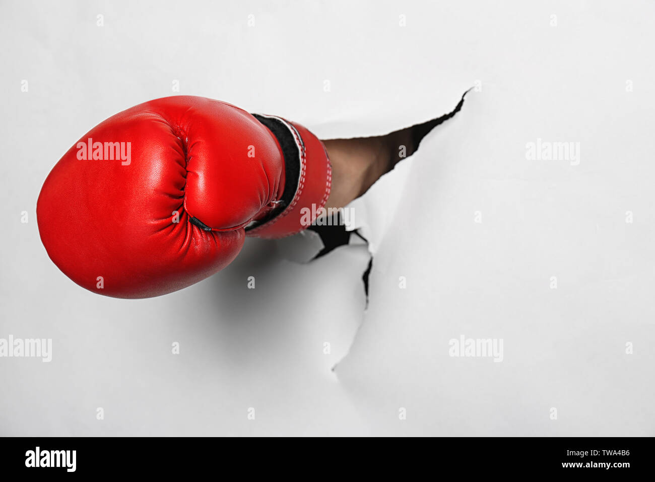 Man in boxing glove breaking through white paper Stock Photo Alamy
