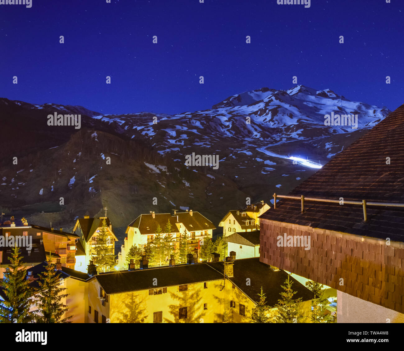 Snow blower working at night in a ski resort in Half snowy mountain in