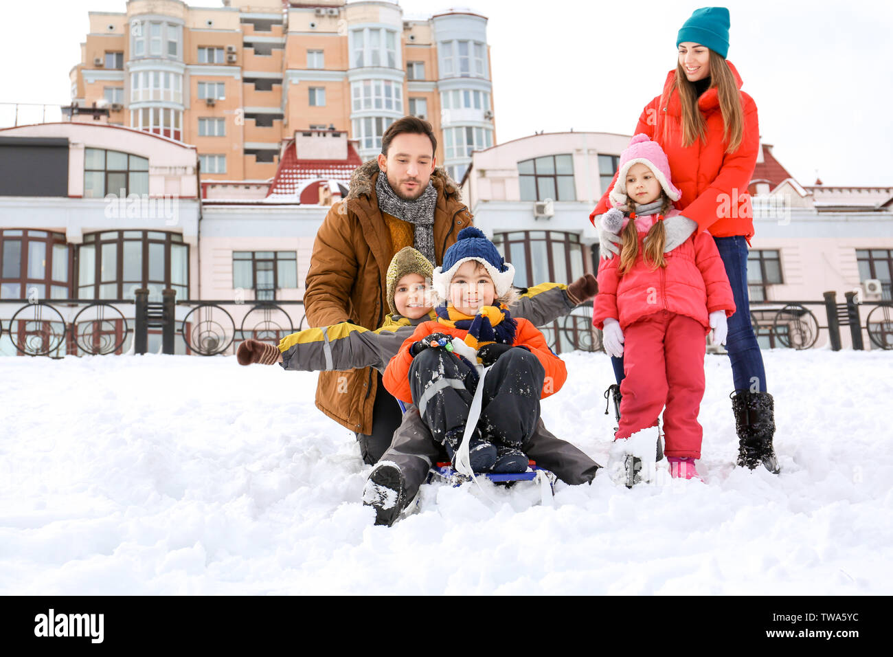 Happy family sledding in snowy park on winter vacation Stock Photo - Alamy