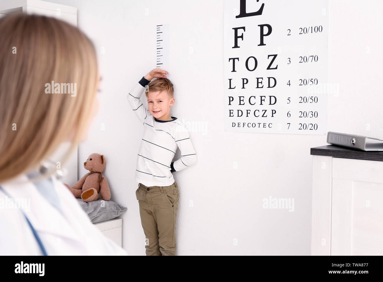 Cute little boy measuring height in hospital Stock Photo