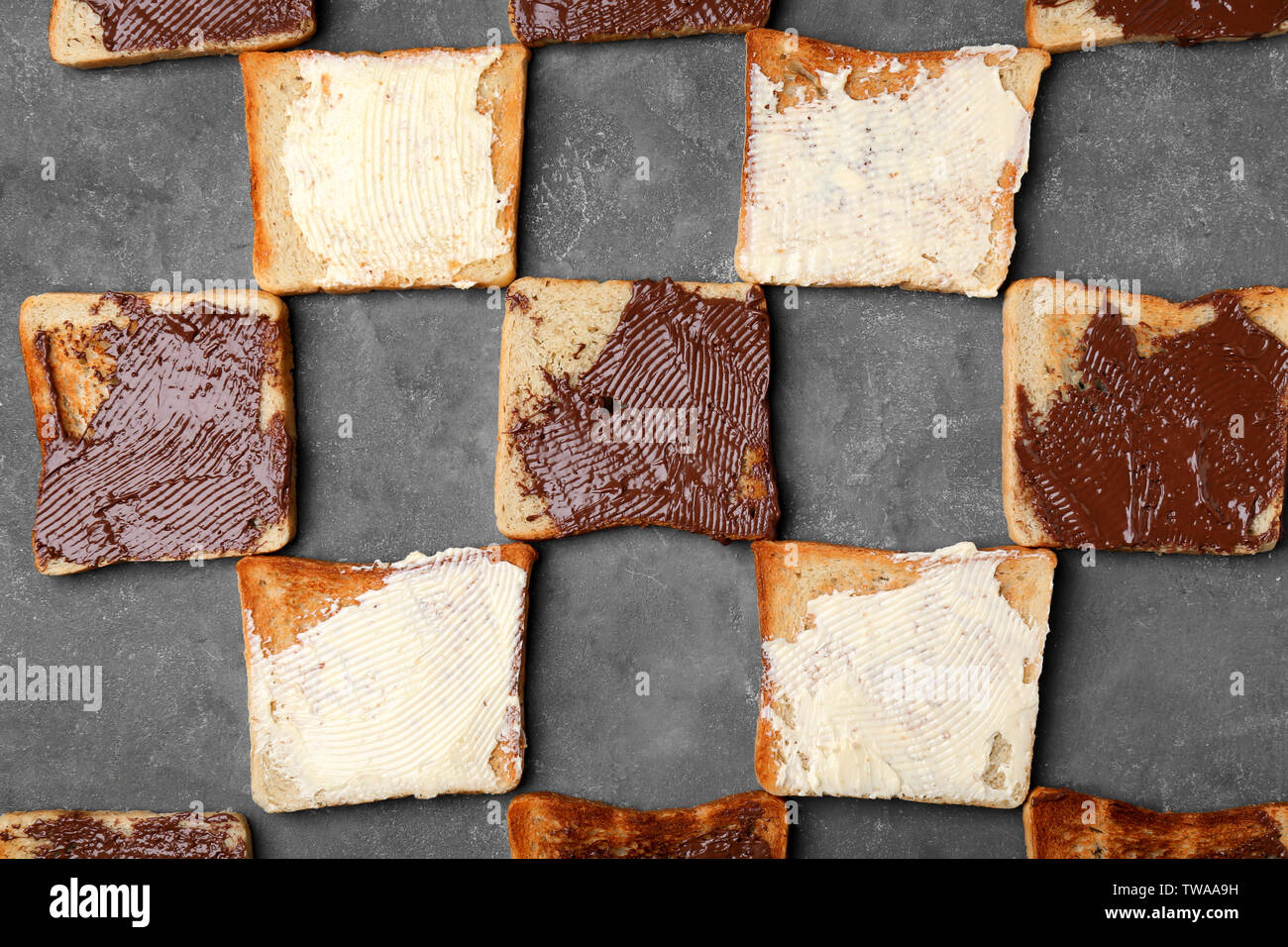 Toasted bread with butter and chocolate paste on grey background Stock ...