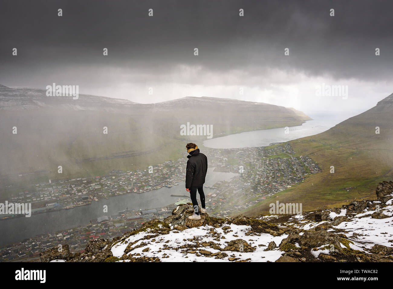 Hiker on the Klakkur mountain above the city of Klaksvik on Faroe Islands Stock Photo