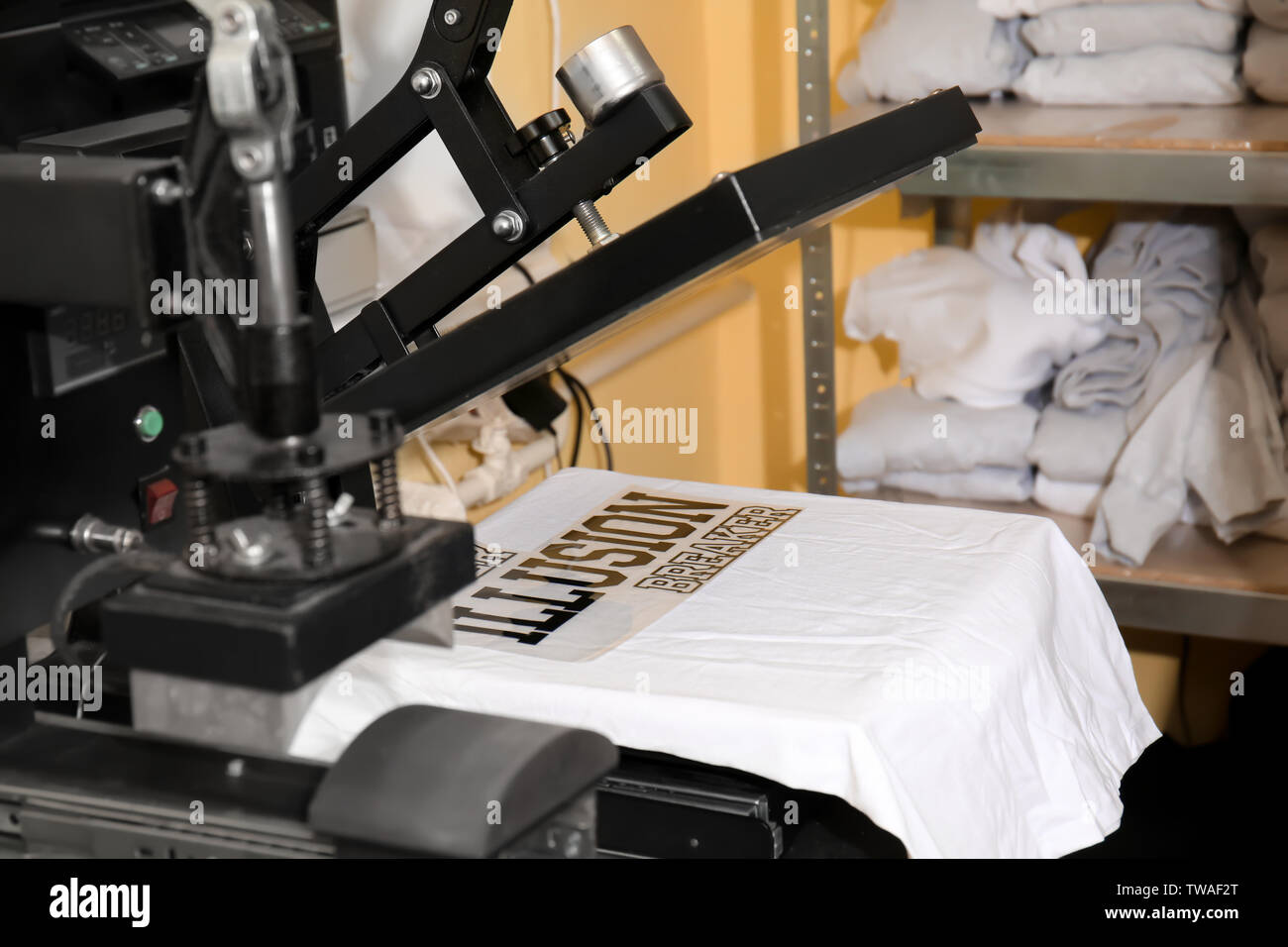 Modern printing machine with t-shirt at workplace Stock Photo