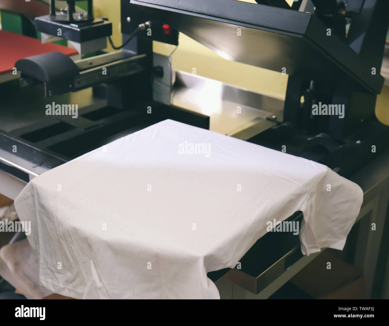 Modern printing machine with t-shirt at workplace Stock Photo