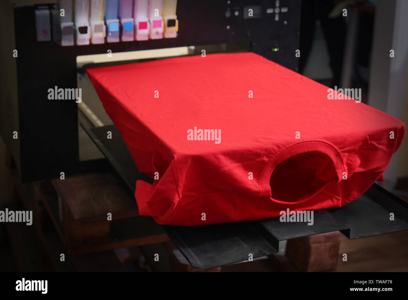 Modern printing machine with t-shirt at workplace Stock Photo