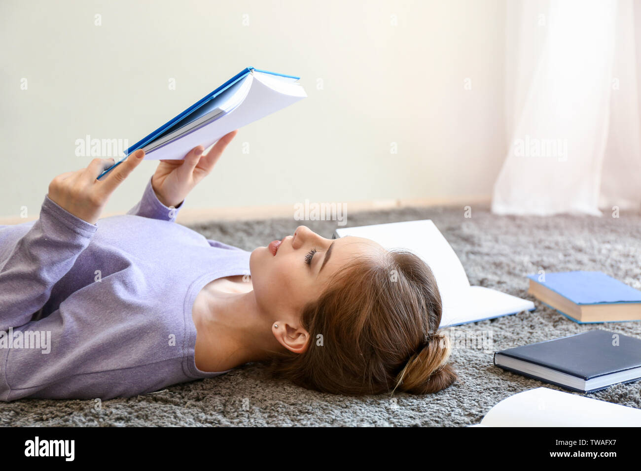 Female student reading books at home Stock Photo - Alamy