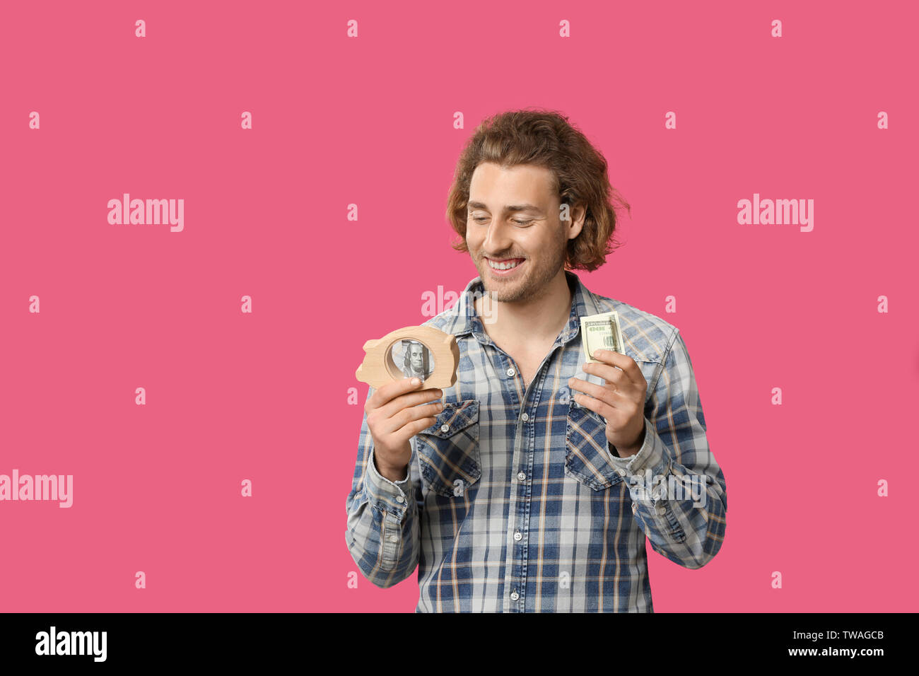 Handsome man with money and piggy bank on color background Stock Photo ...