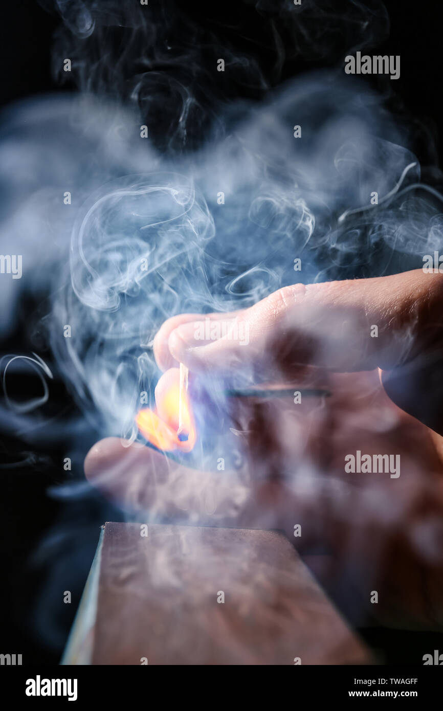 Man striking match on dark background Stock Photo Alamy