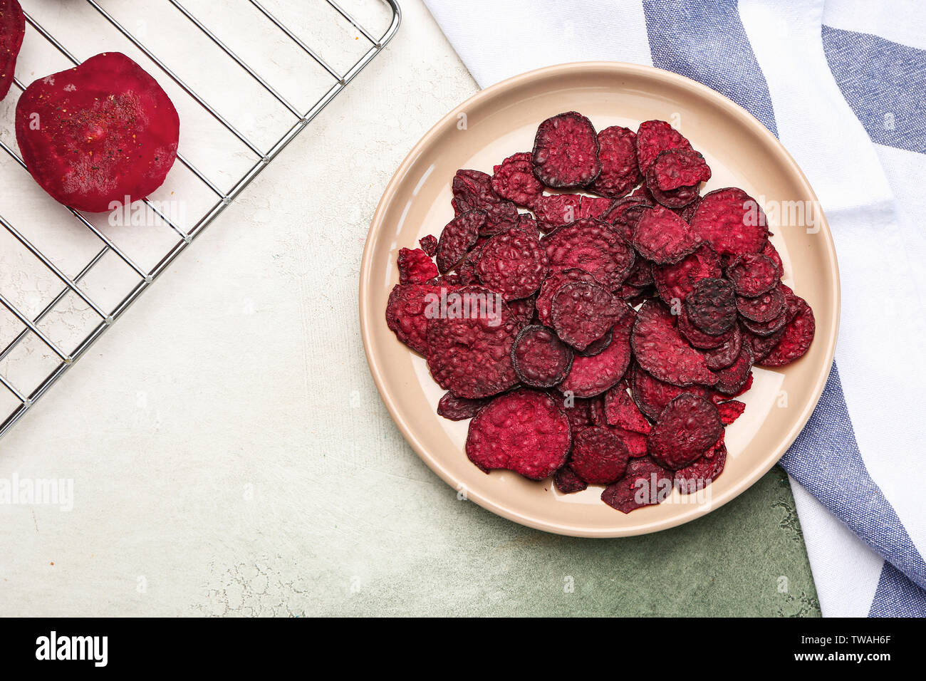Plate with tasty beet chips on table Stock Photo