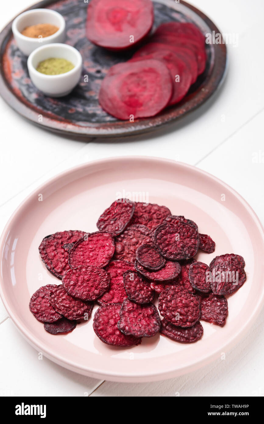 Plate with tasty beet chips on table Stock Photo