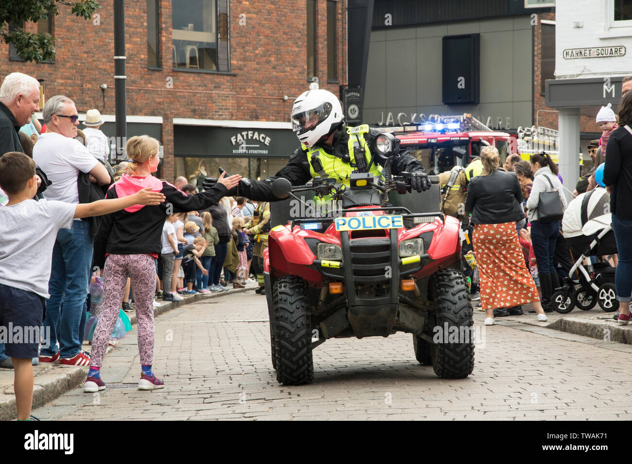 Police motorcyclist giving high fives to the crowds Stock Photo