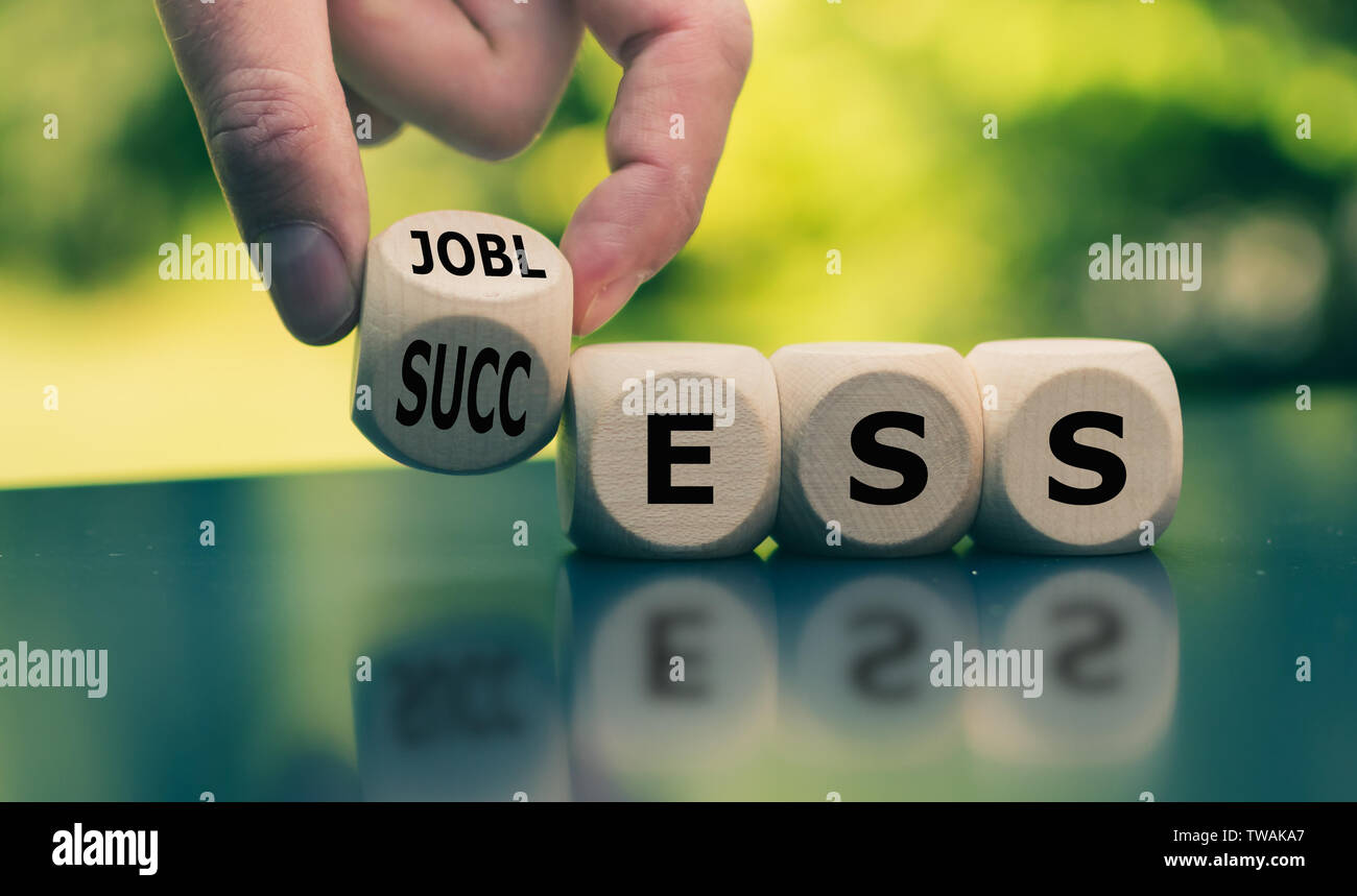Concept of a turning point in life. Hand turns a cube and changes the word 'jobless' to 'success'. Stock Photo