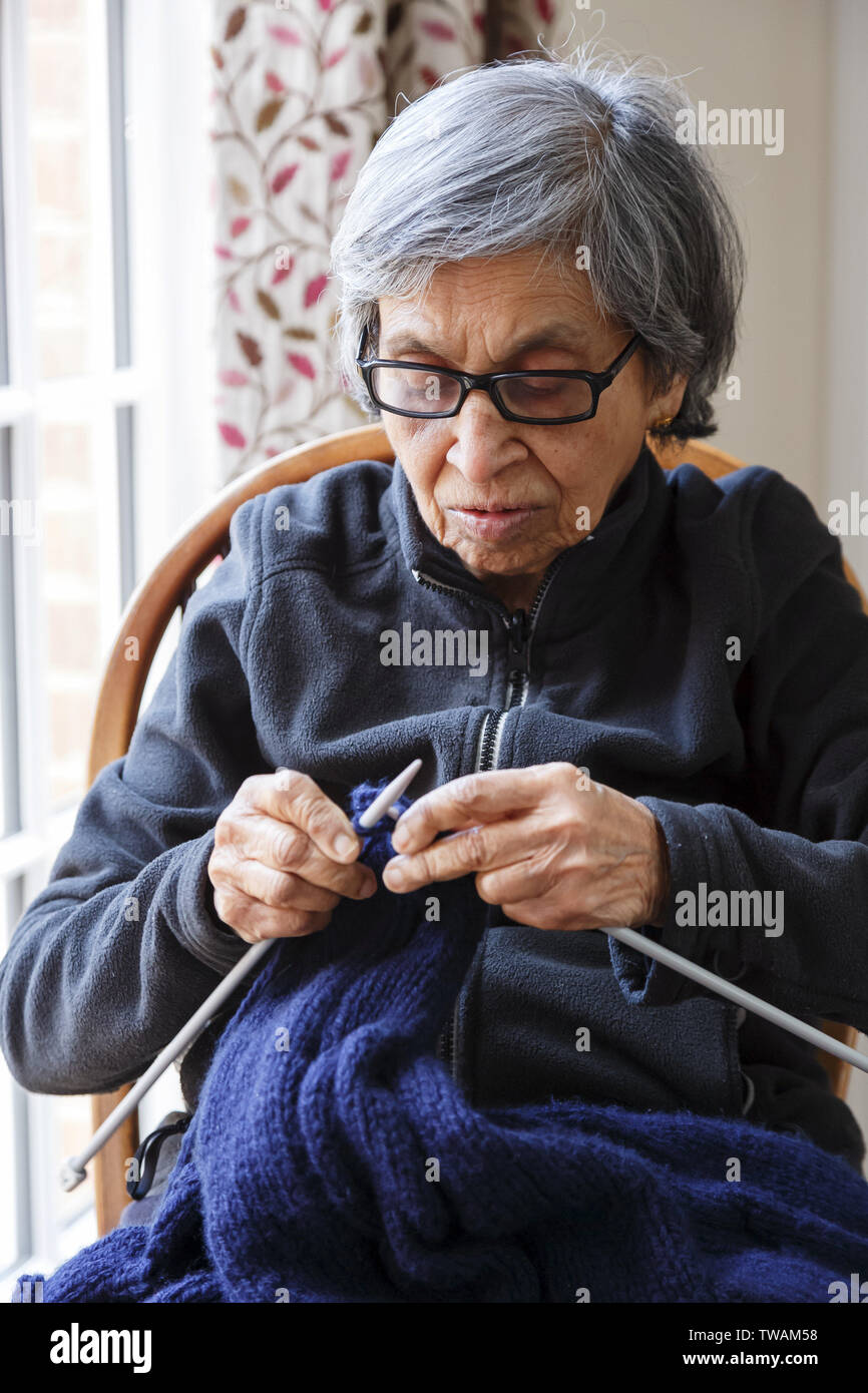 An old Asian Indian woman knits. Depicts the elderly engaged in a hobby or pastime Stock Photo