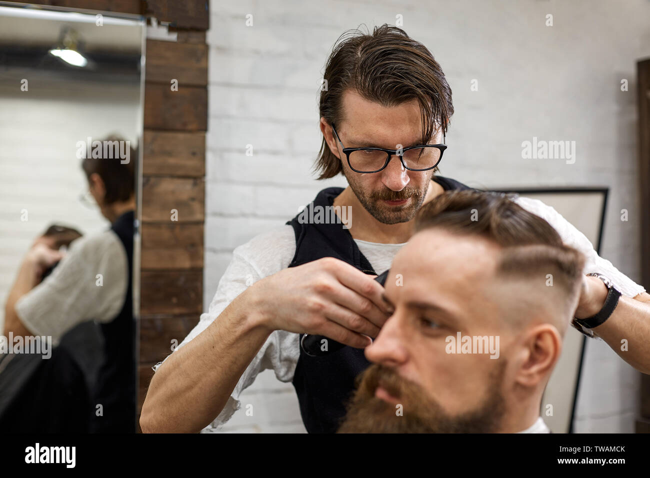 Master Cuts Hair And Beard Of Men In The Barbershop Hairdresser