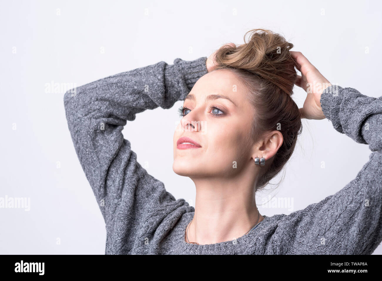 Portrait Of Independent Beautiful Young Woman Making Hair Bun
