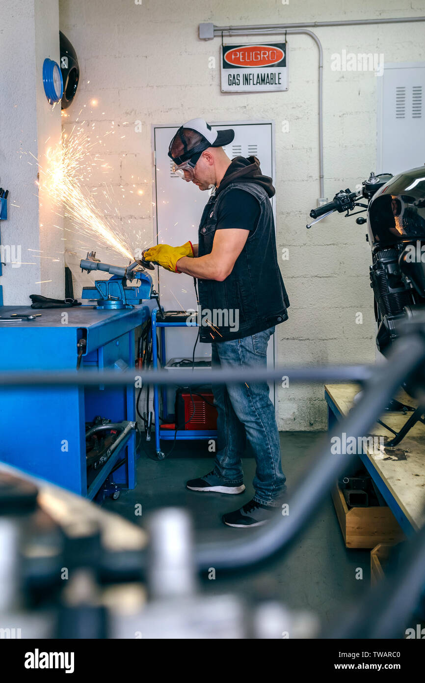 Motorcycle mechanic using a grinder Stock Photo