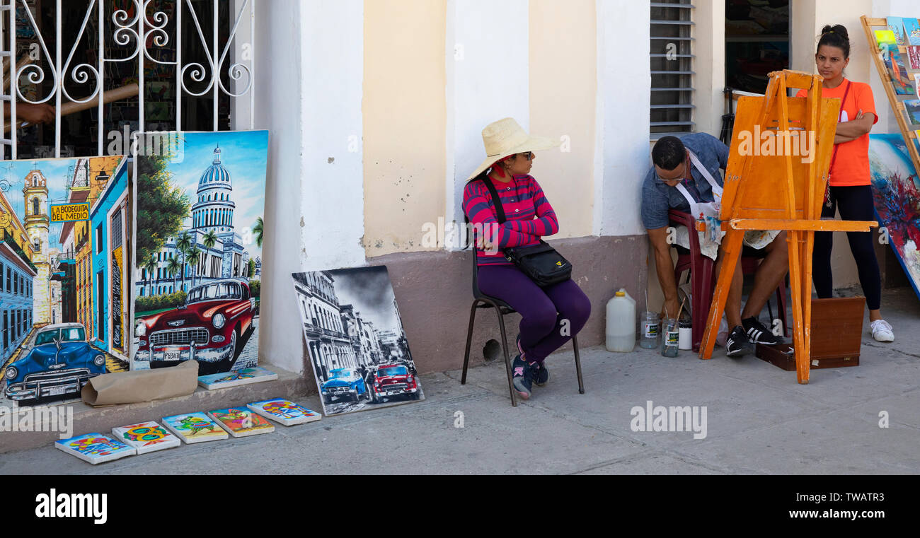 An artist with his work on the street in Cienfuegos. Stock Photo