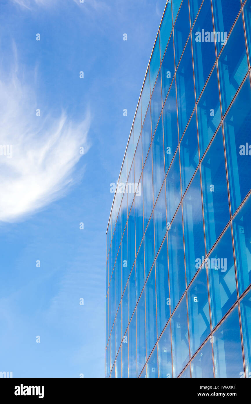 Blue sky with clouds and modern office building with a glass facade ...