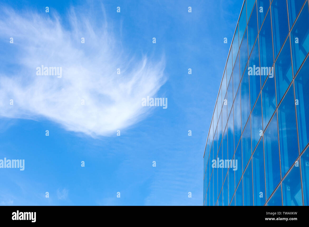 Blue sky with clouds and modern office building with a glass facade ...