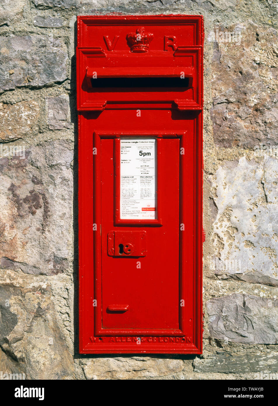 Victorian red post box mounted in Vicarage wall, Cwm village, Denbighshire, North Wales. Bilingual collection sign. Stock Photo