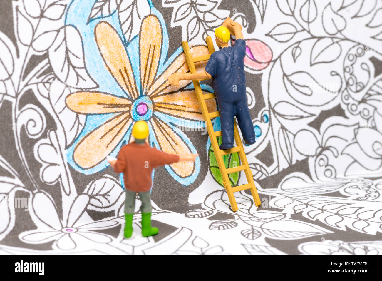 Macro shot on miniature figures as painters working on colouring details on a wallpaper Stock Photo