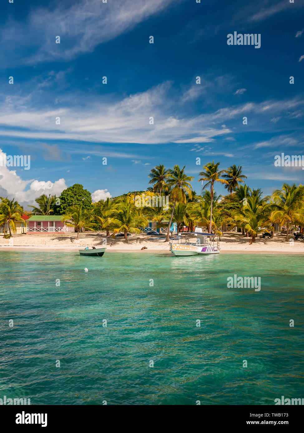 A vertical shot of the coast line of Saona Island in the Dominican Republic with fishing boats on the cost line. Stock Photo