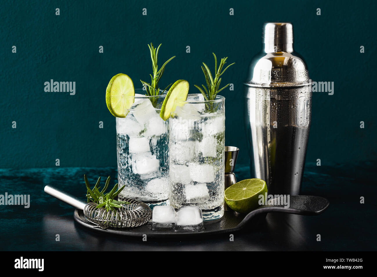 classic gin and tonic cocktail with rosemary sprigs in tall glasses on