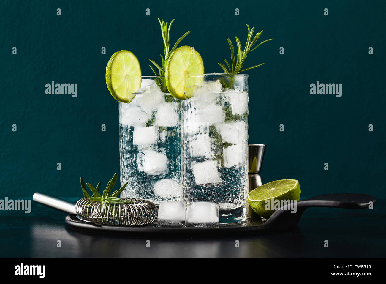 classic gin and tonic cocktail with rosemary sprigs in tall glasses on