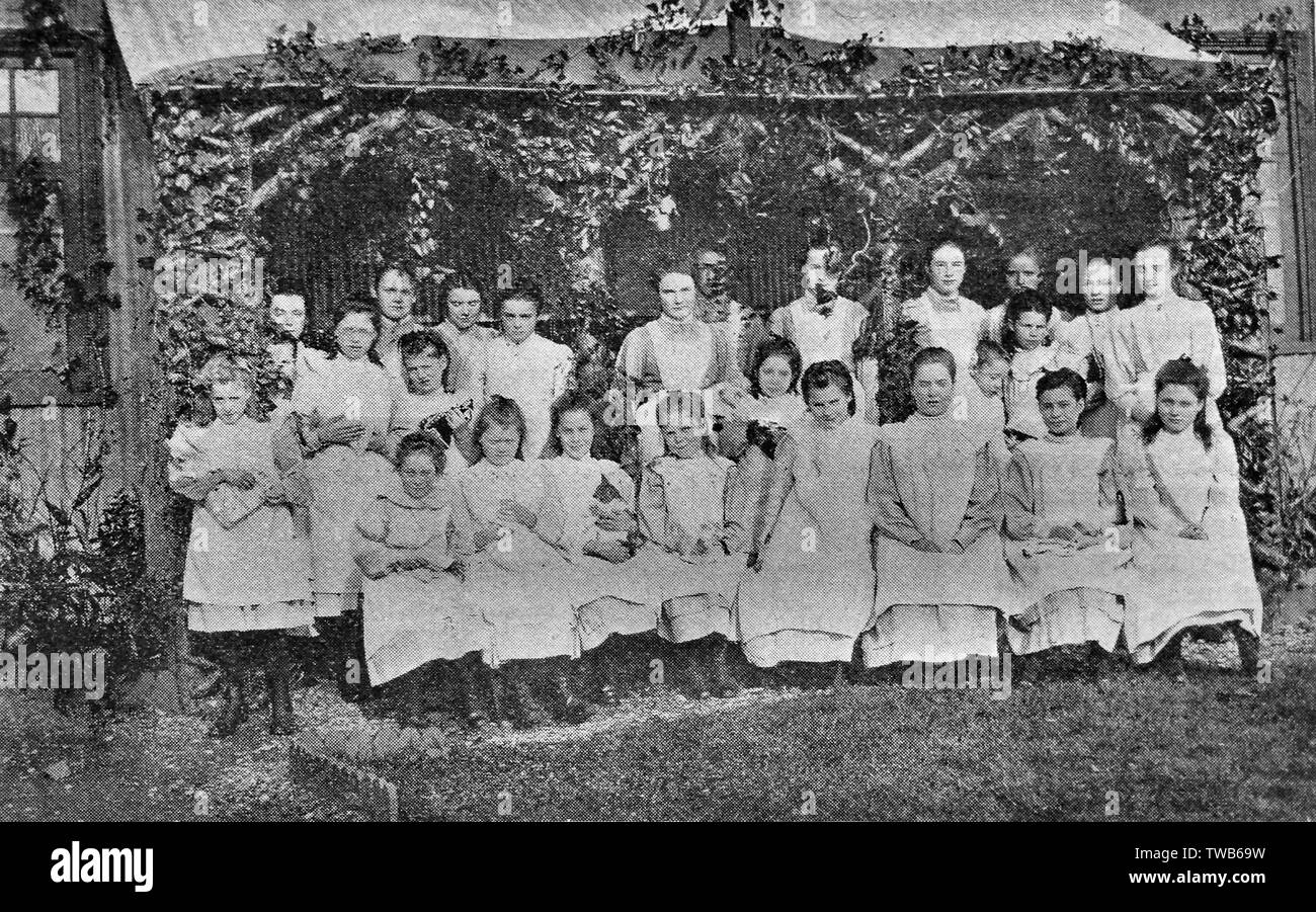 Inmates (and the home's cat) in the garden of St Michael's Girls' Home at Shipton under Wychwood run by the Waifs and Strays Society. circa 1907 Stock Photo