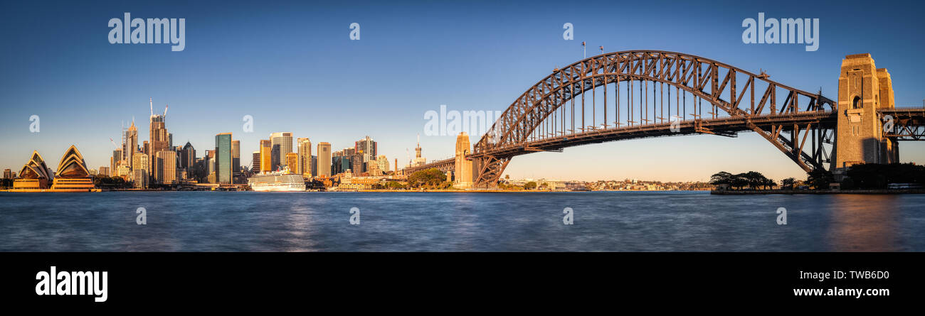 Sydney Harbour Bridge and Opera House Panorama with blue sky and water in daylight, Sydney Australia  Sunrise, not night, Wide. Stock Photo