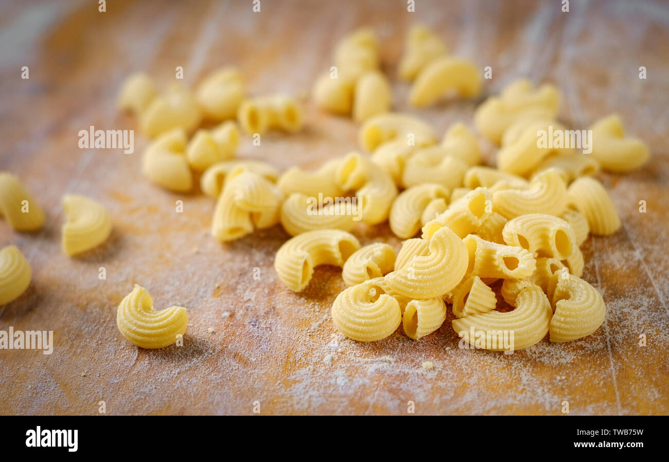 fresh Elbow pasta made at home on a wooden table with flour Stock Photo