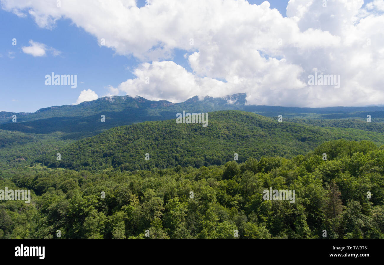 Aerial view. Summer mountain landscape. Forested mountains and clouds. Stock Photo