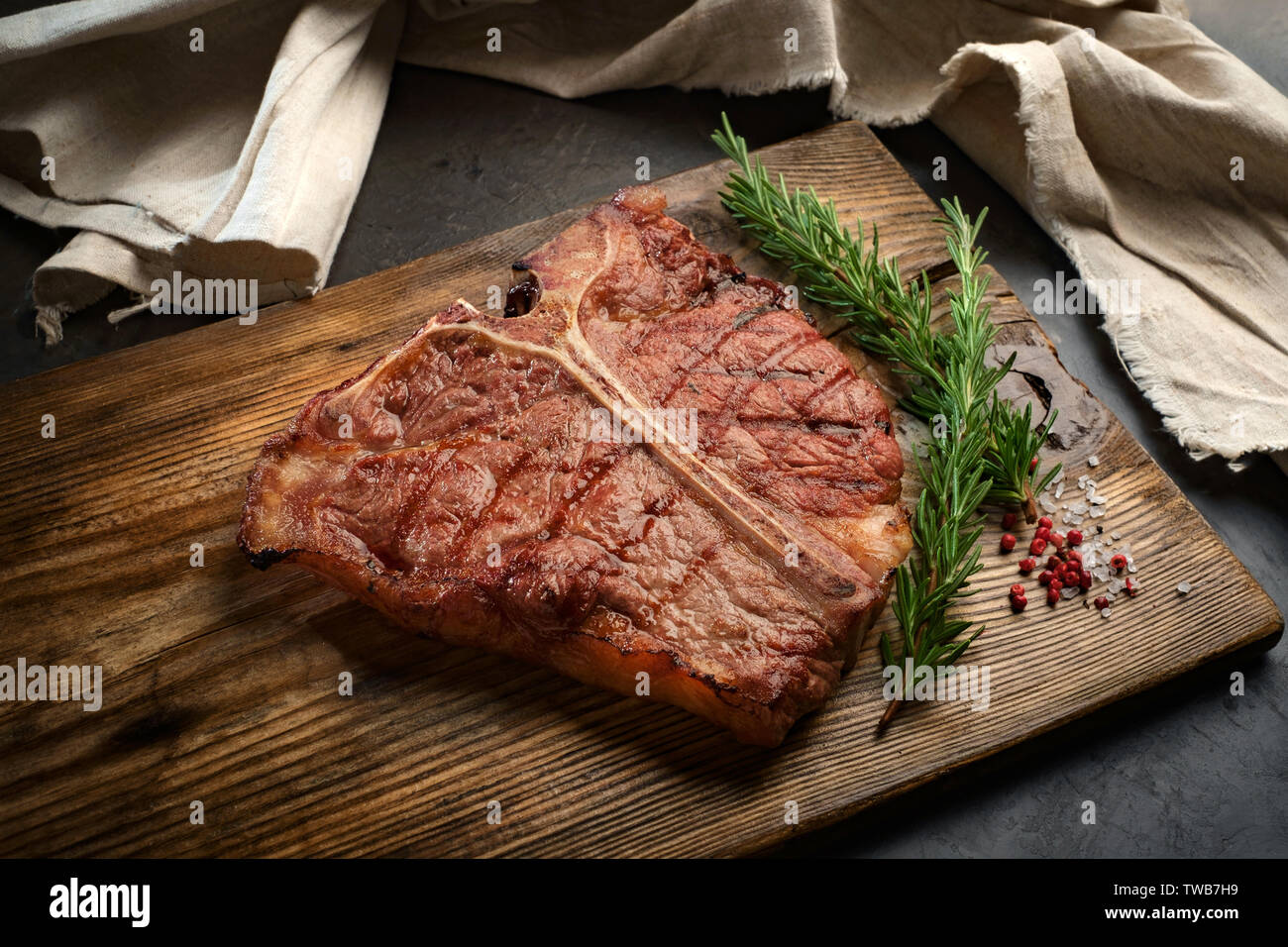 https://c8.alamy.com/comp/TWB7H9/porterhouse-beef-steak-cooked-on-a-grill-on-a-wooden-board-TWB7H9.jpg