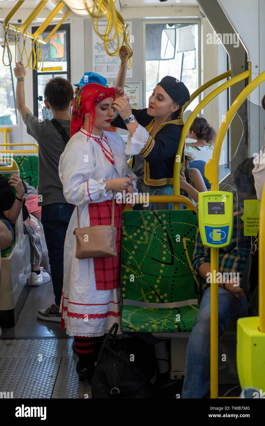Women on a Melbourne tram attend to their traditional costumes on their way to the Greek Festival. Stock Photo